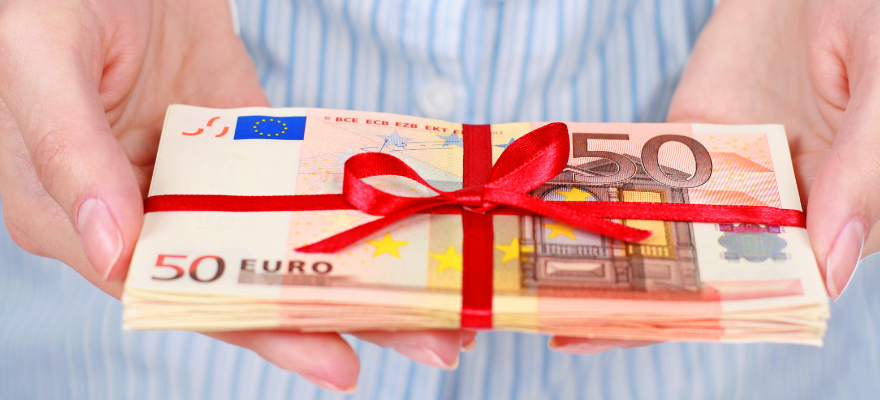 Lotto Brandenburg Gewinnauszahlung: Das müssen Sie wissen. Geldscheine mit roter Schleife gebunden